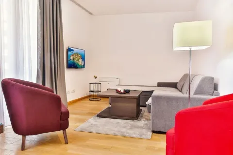 Living room with a sofa, armchairs, and a wall-mounted TV. - image 5