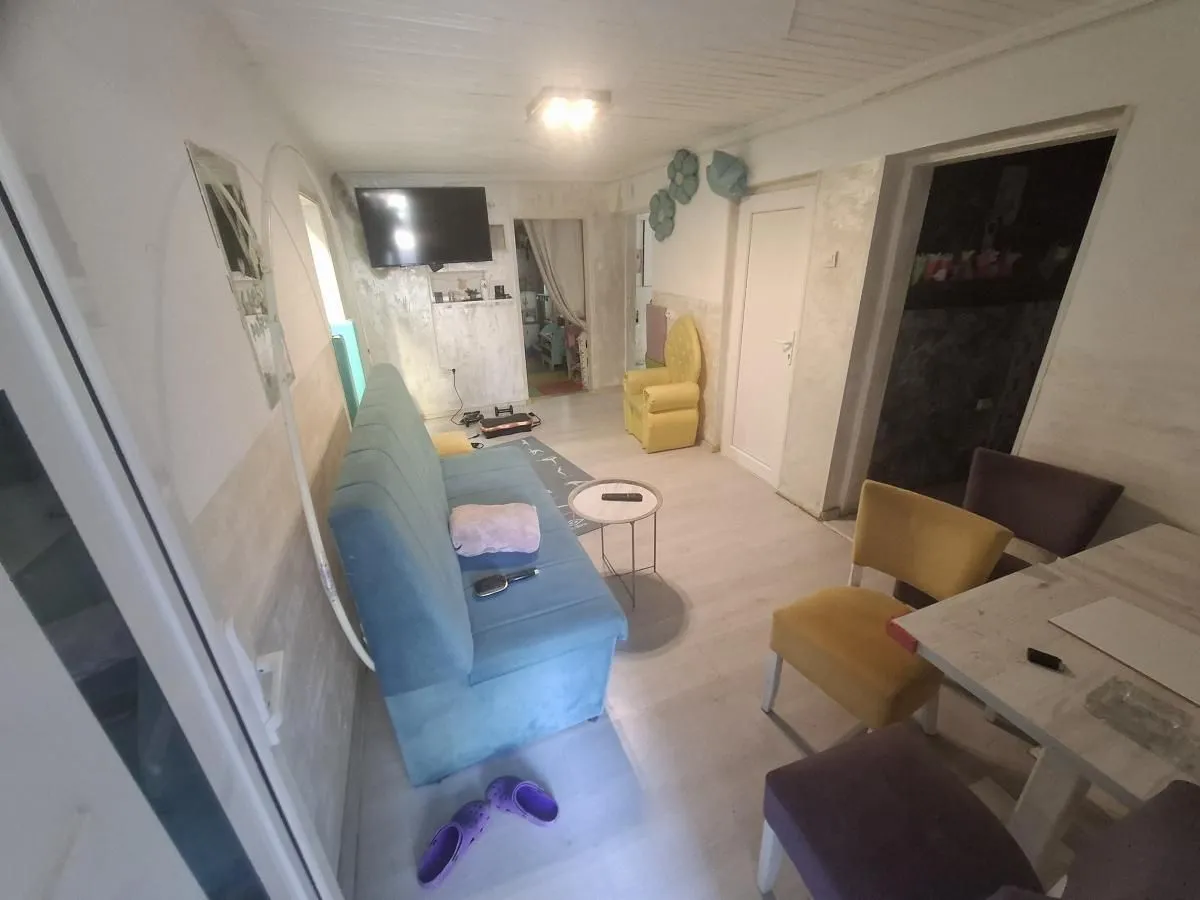 Living room with a sofa, TV, and dining table.