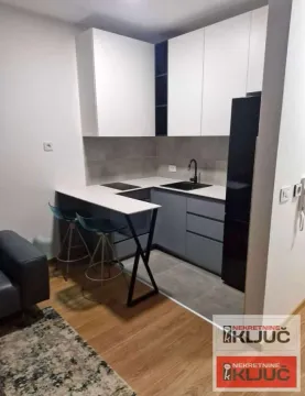 Moderna kuhinja sa belim i sivim elementima i šankom. - image 3