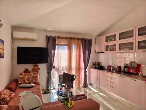 Dnevni boravak povezan sa kuhinjom sa garniturom i televizorom. - image 9