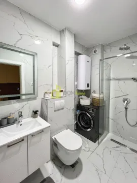 Modernly equipped bathroom with a walk-in shower, washbasin, and washing machine. - image 3