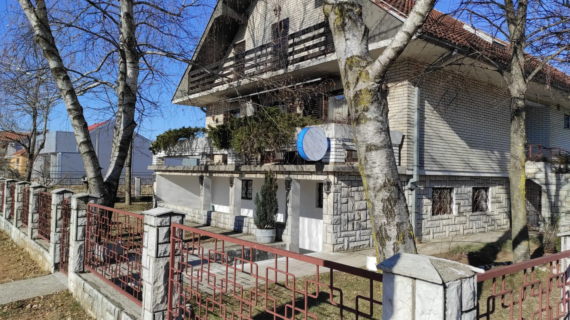 Exterior view of the house with yard and fence.