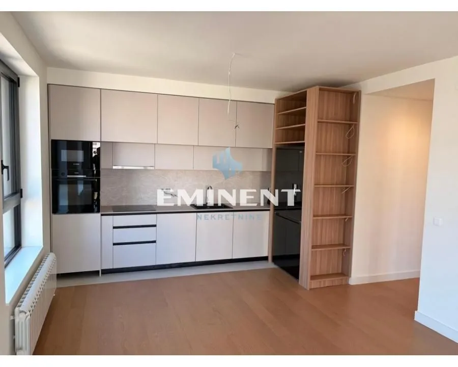Modern kitchen with built-in cabinetry and a wooden shelving unit in an open space.