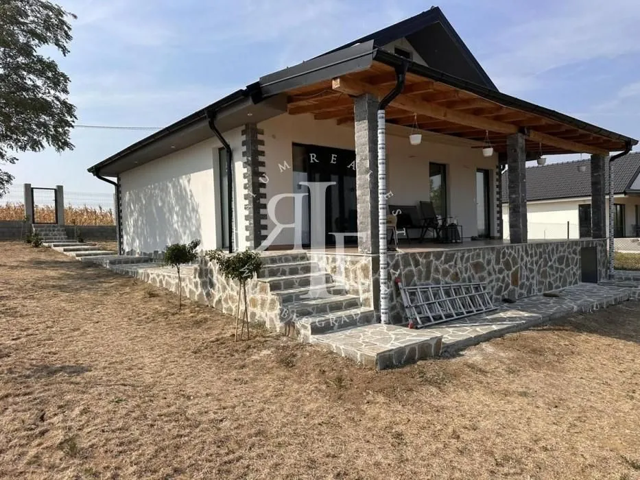 Exterior view of the house with a covered terrace and stone stairs.