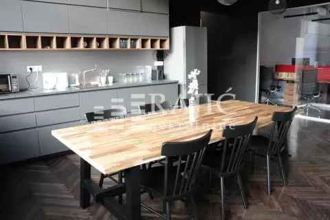 Kitchen with a dining table and grey cabinets. - image 4