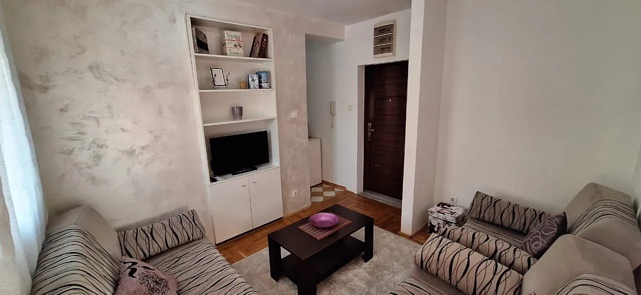 Living room with seating furniture, a coffee table, and a built-in cabinet with a TV.