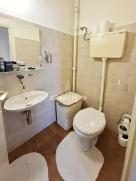 Manje kupatilo sa umivaonikom, WC šoljom i pločicama na zidovima. - image 14