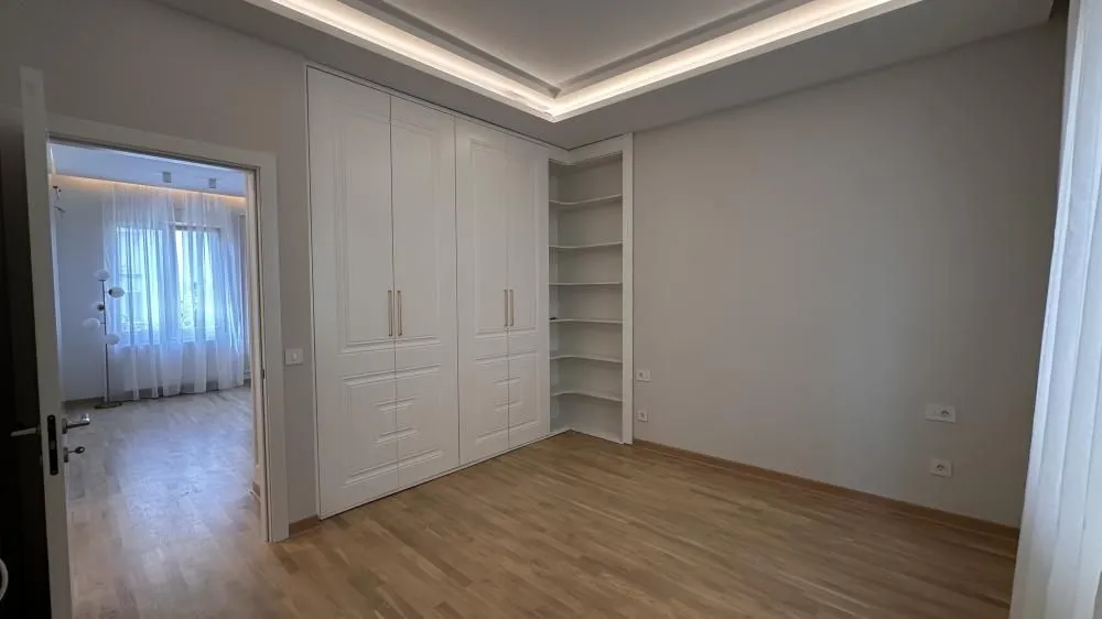 Bedroom featuring a built-in wardrobe and open shelving units.