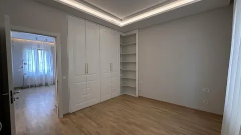 Bedroom featuring a built-in wardrobe and open shelving units. - image 5
