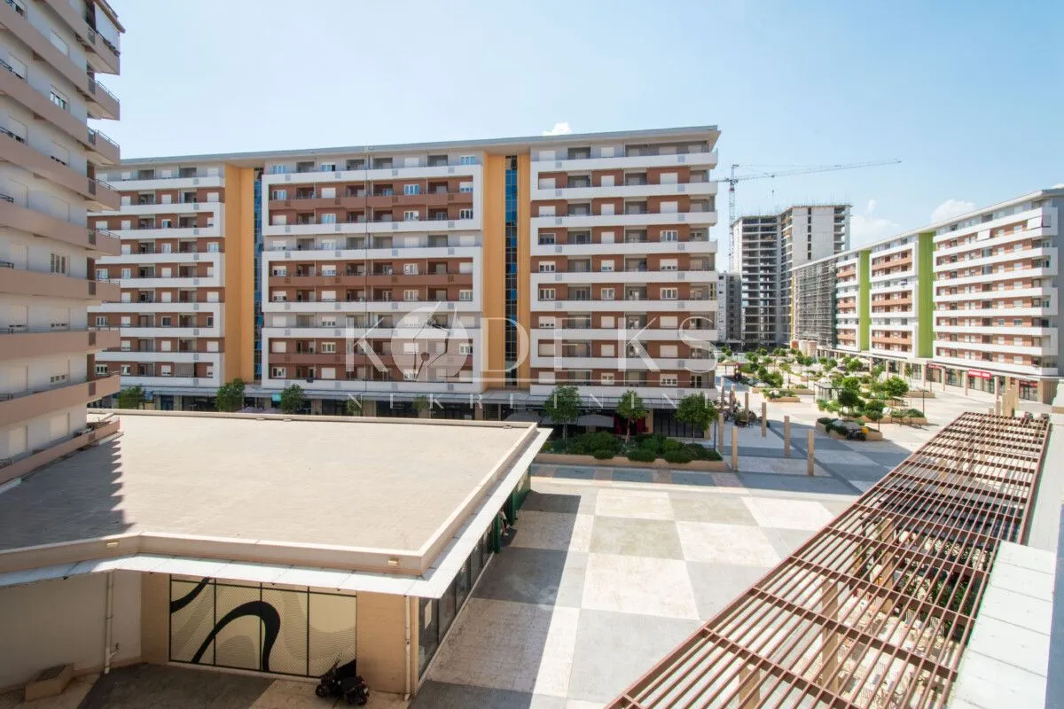 Exterior view of a modern residential complex and landscaped square.