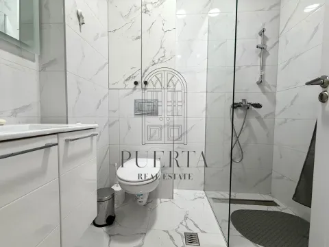 Modern renovated bathroom with a walk-in shower and white marble tiles. - image 8