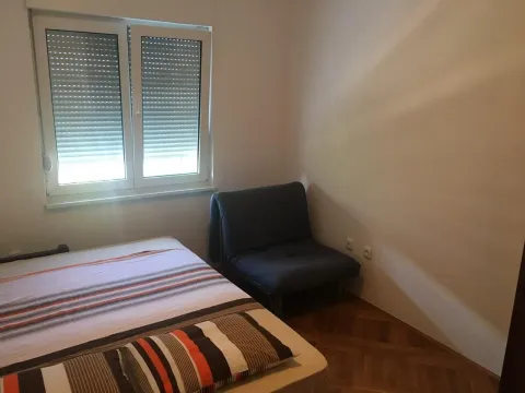 Jednostavno namještena spavaća soba sa prozorom i foteljom na razvlačenje. - image 5