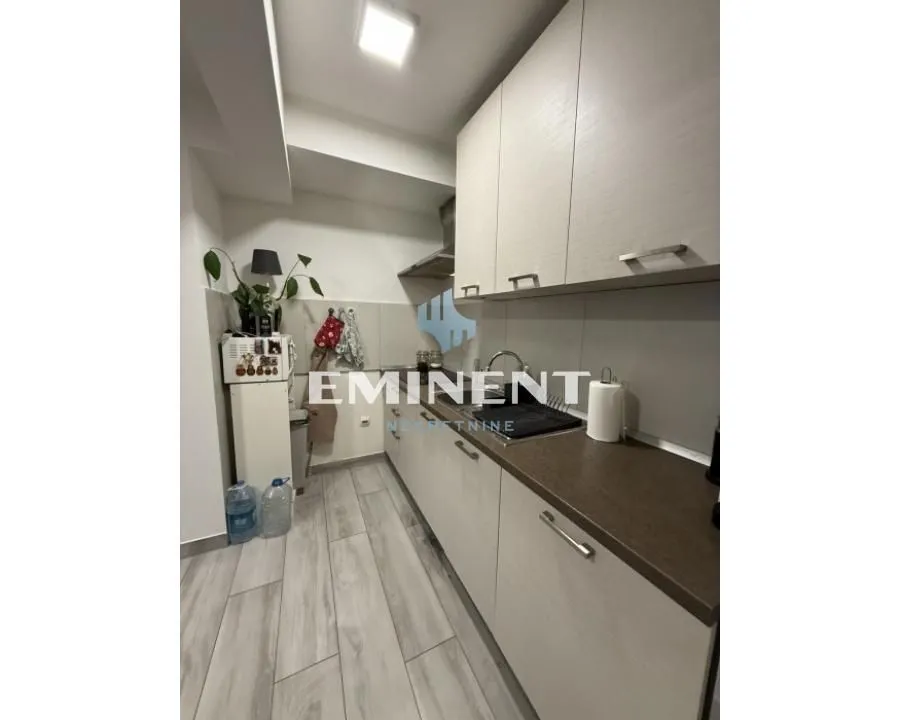 Compact kitchen with light-colored cabinets and built-in appliances.