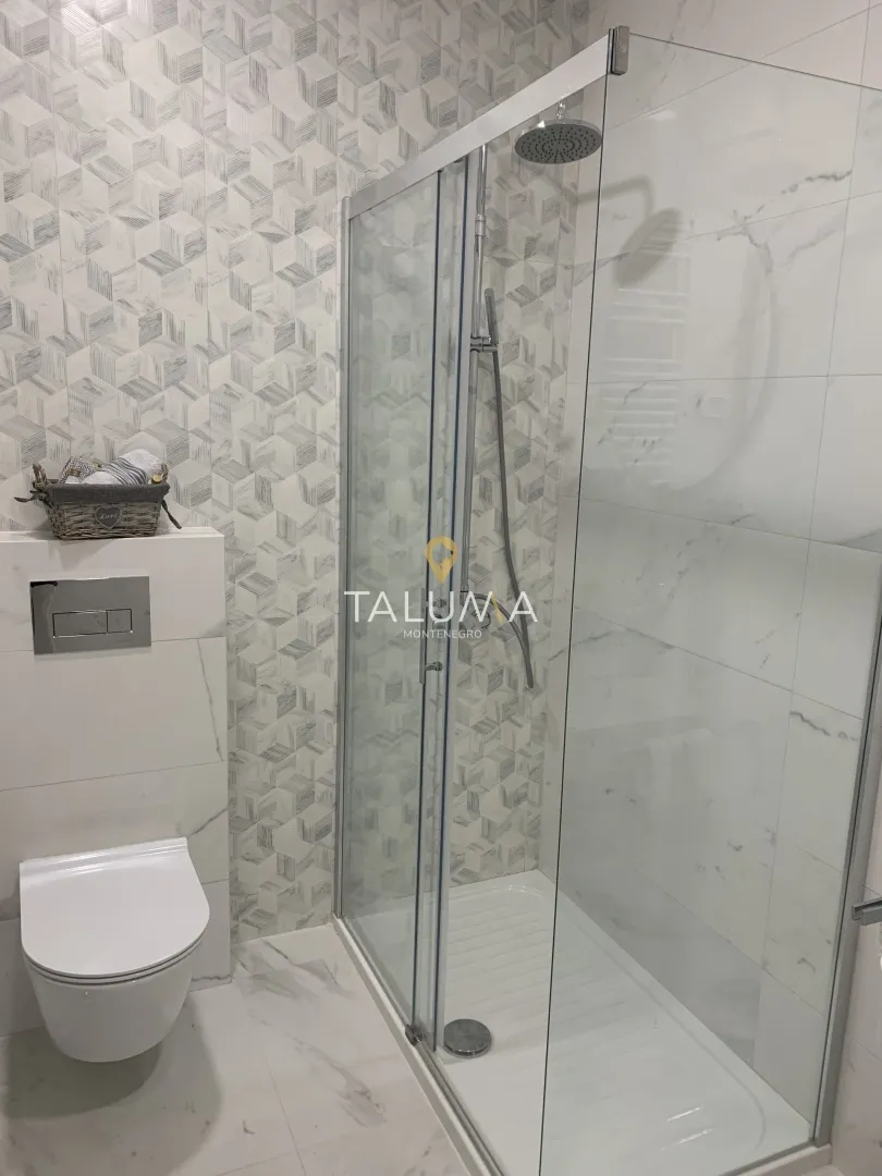 Moderne kupatilo sa tuš kabinom i ugradnom wc šoljom.