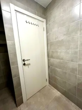 Kupatilo sa popločanim zidovima i bijelim vratima. - image 8