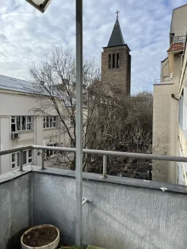 View from the balcony towards surrounding buildings and a church. - image 6