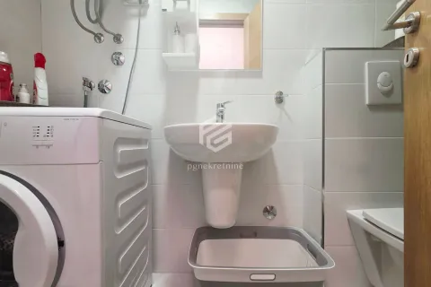 Bathroom equipped with a washbasin, toilet bowl, and washing machine. - image 5