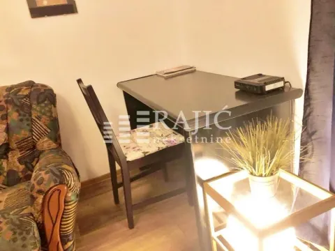 Part of the living room with a table, chair, and armchair. - image 3