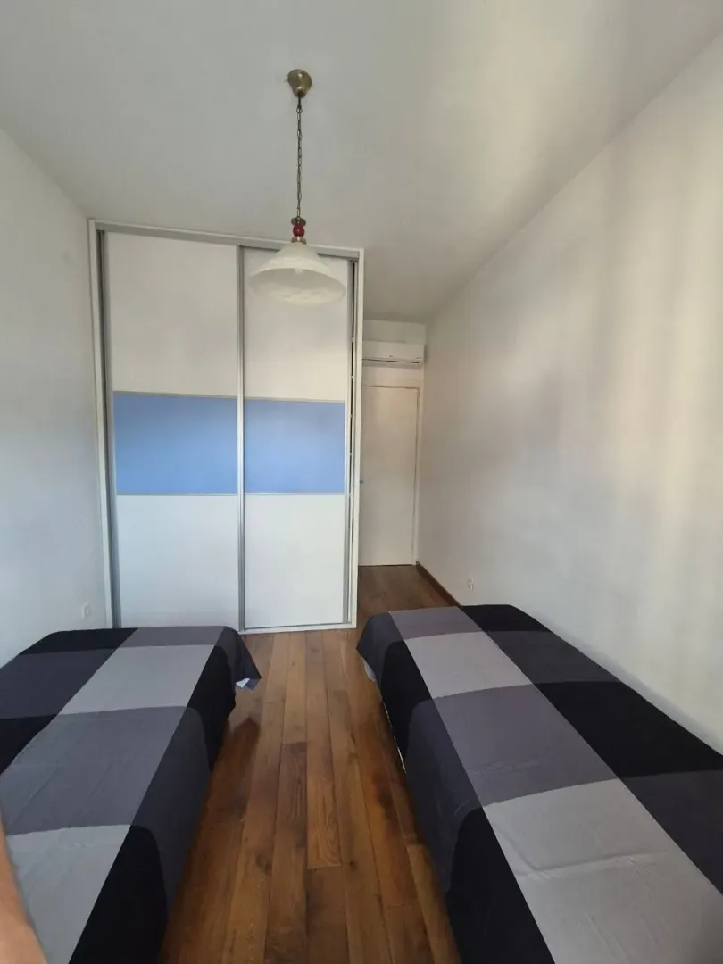 Small bedroom with two single beds and a built-in wardrobe.