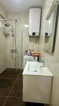 Moderno opremljeno kupatilo sa tuš kabinom, umivaonikom i veš mašinom. - image 8
