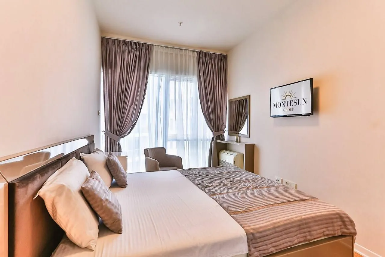 Furnished bedroom with a large double bed and a window with curtains.