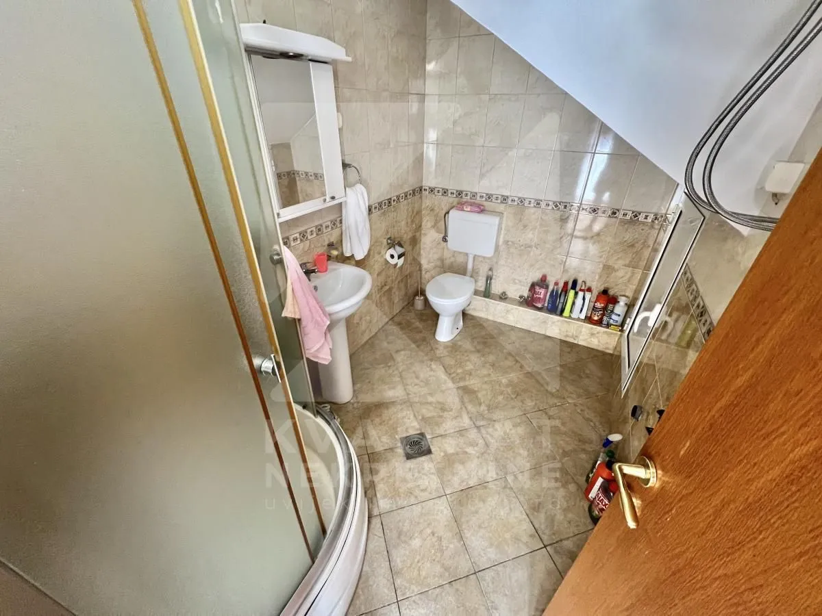Bathroom with a shower cabin, washbasin, and toilet.