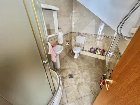 Bathroom with a shower cabin, washbasin, and toilet. - image 13