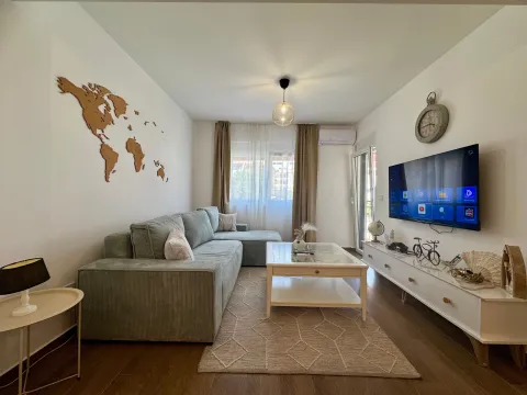 Bright living room with a corner sofa, TV, and decorative world map on the wall. - image 2