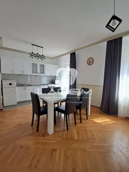 Kuhinja sa trpezarijom i belim elementima.