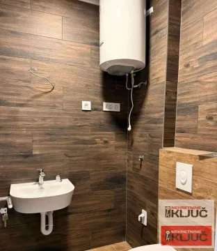 Manje kupatilo obloženo keramičkim pločicama u imitaciji drveta sa umivaonikom i bojlerom. - image 4