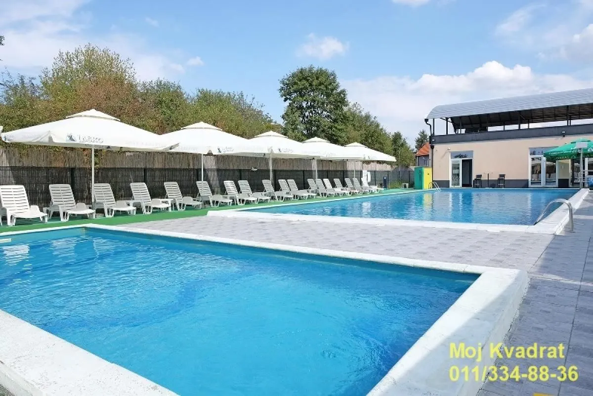 Outdoor swimming pools with sun loungers and umbrellas in the property yard.
