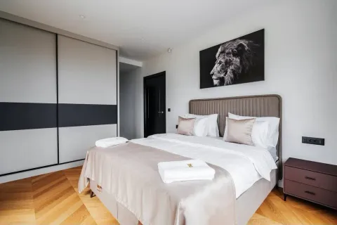 Modern bedroom with a double bed, built-in wardrobe, and parquet flooring. - image 9