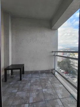 Natkriveni balkon sa popločanim podom i pogledom na gradsku ulicu. - image 2