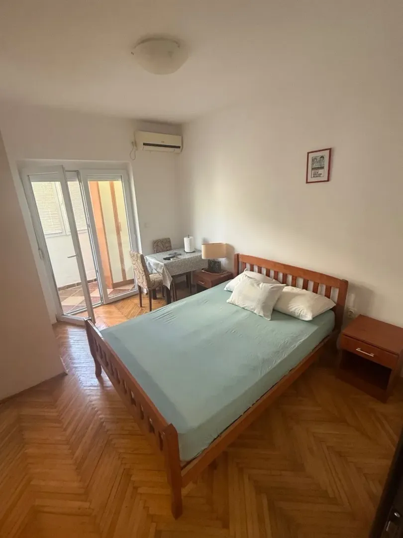 Spavaća soba sa bračnim krevetom i izlazom na terasu.