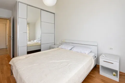 Bedroom with a double bed, white mirrored wardrobe and a bedside table. - image 9