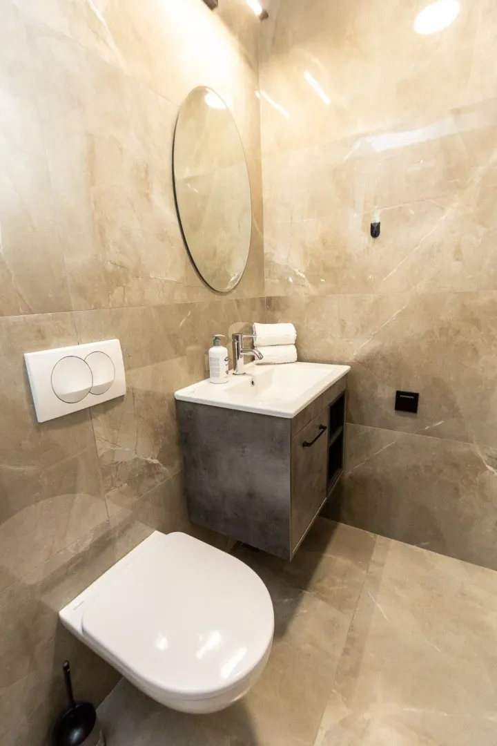 Modernly equipped bathroom with a sink and toilet bowl.