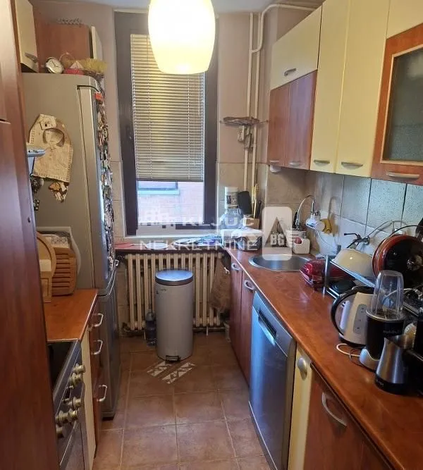 Manja, uska kuhinja sa drvenim elementima i aparatima.