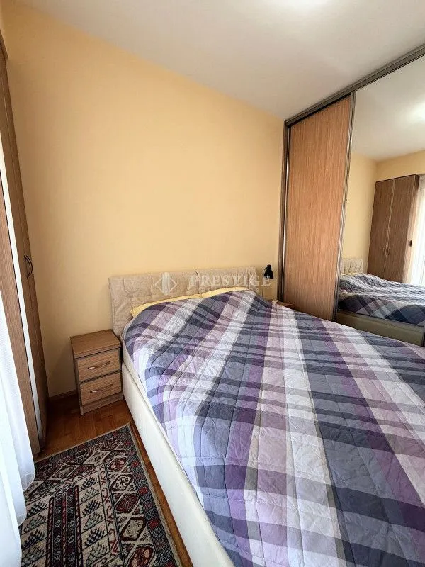 Furnished bedroom with a double bed and a large built-in wardrobe with a mirror.