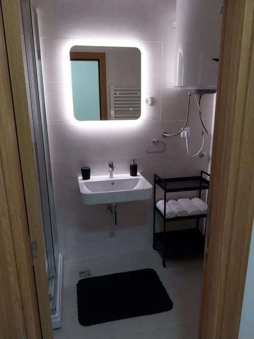Modern bathroom with an illuminated mirror and a sink.
