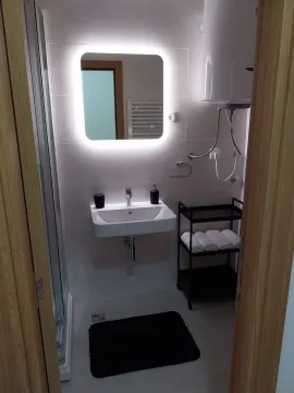 Modern bathroom with an illuminated mirror and a sink. - image 9