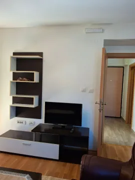 Dnevna soba sa TV komodom i policama na zidu. - image 4