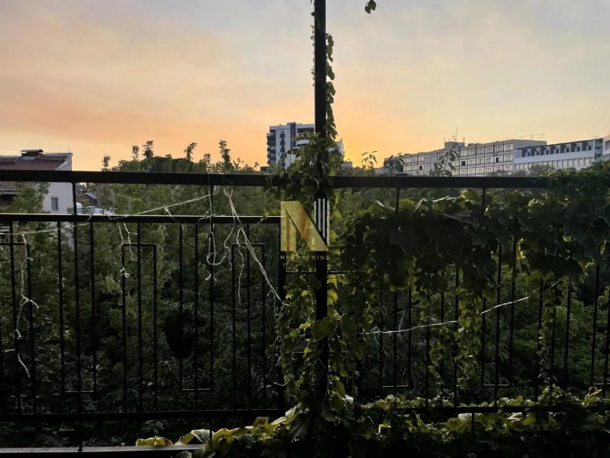 Pogled sa terase ukrašene zelenilom i ogradom tokom zalaska sunca.