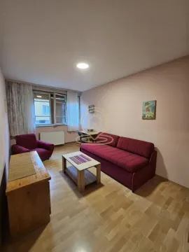 Dnevna soba sa crvenom sofom, foteljom i drvenim stočićem. - image 2