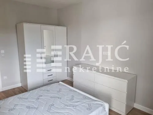 Furnished bedroom with a white wardrobe, bed, and dresser.