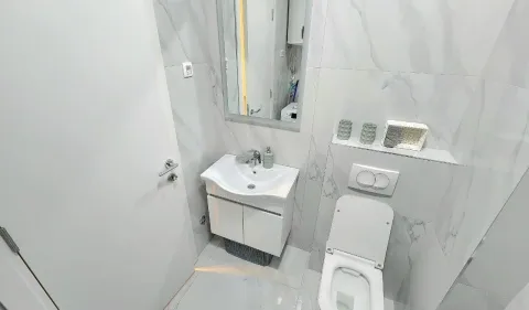 Moderno opremljeno kupatilo sa umivaonikom, WC šoljom i ogledalom. - image 8