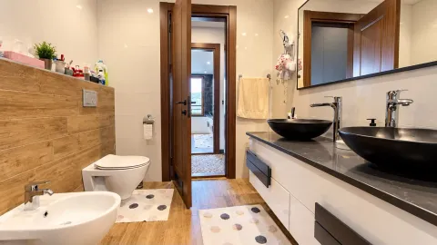 Moderno opremljeno kupatilo sa duplim umivaonikom i drvenim detaljima. - image 12