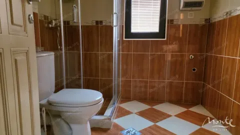 Kupatilo obloženo keramičkim pločicama sa tuš kabinom i toaletom. - image 21