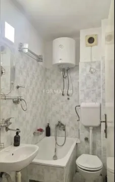 Manje kupatilo sa kadom, umivaonikom, toaletom i bojlerom na zidu. - image 7