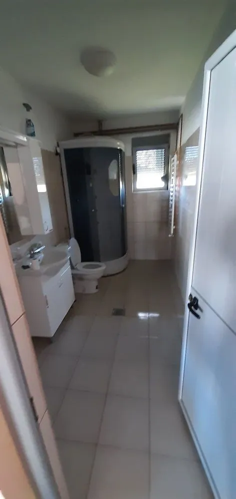 View of the bathroom with a shower cabin, sink, and toilet.