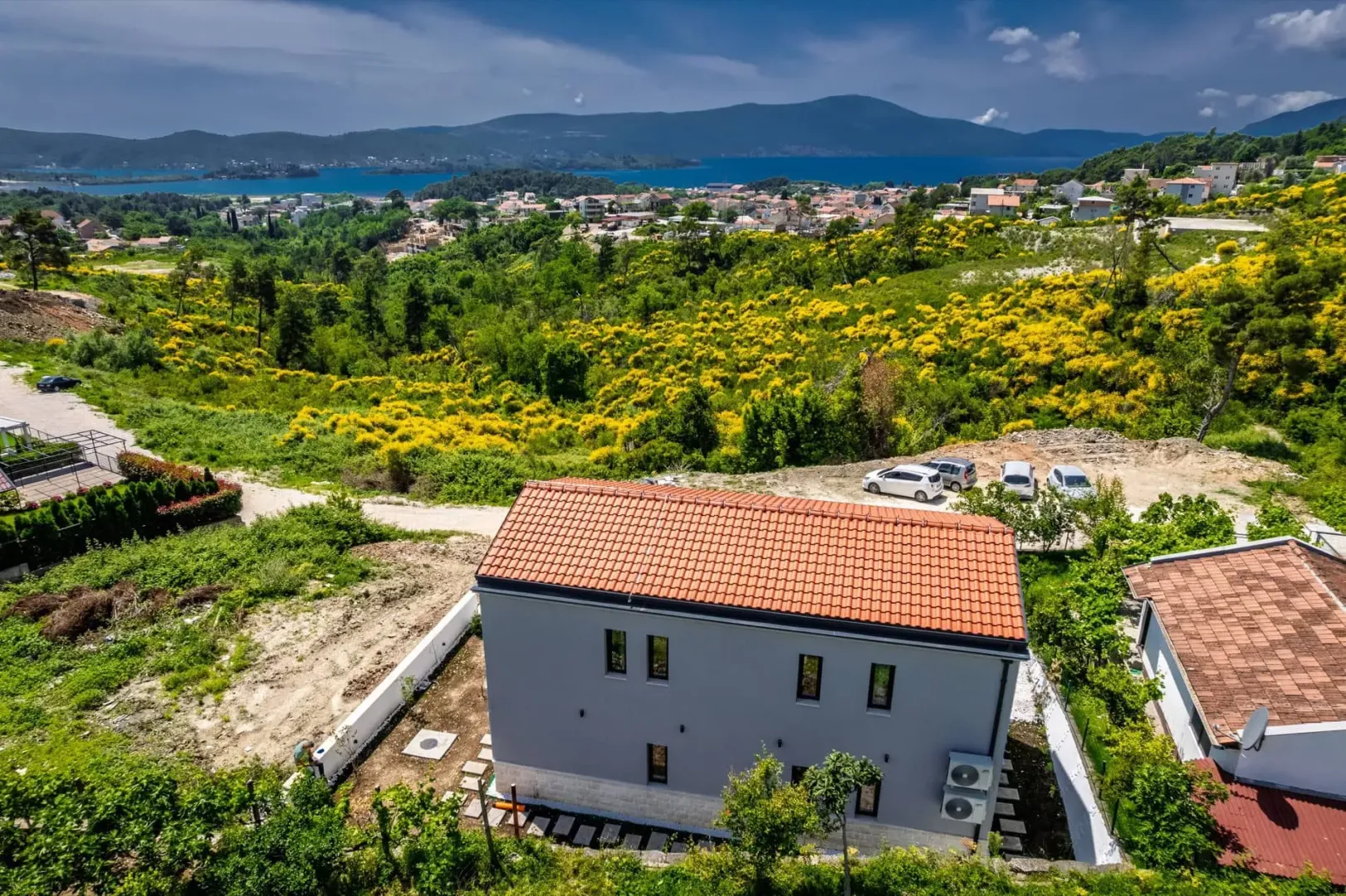 Pogled iz vazduha na novu kuću sa dvorištem i pogledom na more.